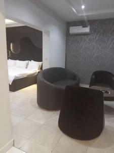 a bedroom with a black chair and a bed at Triple 9 Apartments,Pool & Spa in Abuja