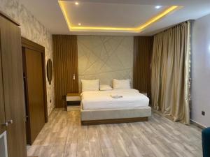 a bedroom with a white bed in a room at Triple 9 Apartments,Pool & Spa in Abuja