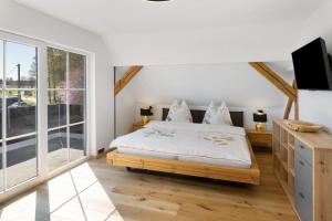 a bedroom with a bed and a large window at Vogtlandstadl - Vogtland Chalet in Bad Brambach