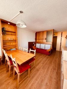 a room with a table and chairs and a bed at Stud 4 Pers Roche Béranger piscine in Chamrousse