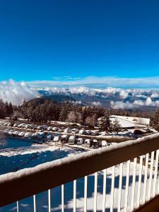 a snow covered balcony with a view of a parking lot at Stud 4 Pers Roche Béranger piscine in Chamrousse