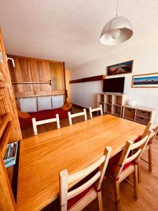 a dining room with a large wooden table and chairs at Stud 4 Pers Roche Béranger piscine in Chamrousse +12 photos