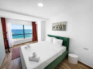 a bedroom with a bed with a view of the ocean at Olimp Sea View Apartments by Maritimo in Olimp