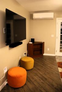 a living room with a tv and an orange stool at Retreat on First Street in Prescott