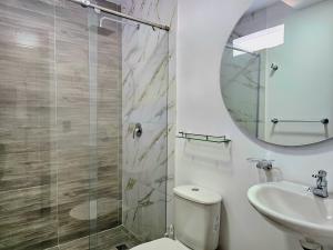 a bathroom with a toilet and a sink and a mirror at Hotel Casa Cristales in Cali +27 photos