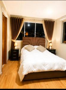 a bedroom with a white bed with two night stands at Precioso Monoambiente Independiente in La Paz