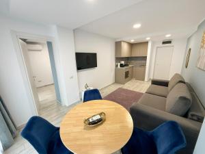 a living room with a table and a couch at Olimp Sea View Apartments by Maritimo in Olimp