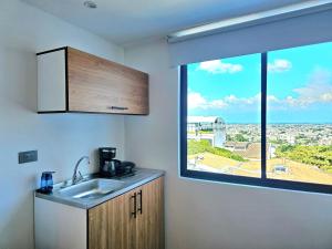 a kitchen with a sink and a large window at Hotel Casa Cristales in Cali