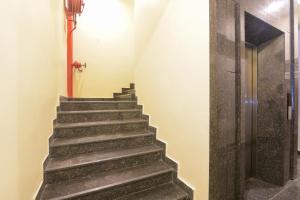 a staircase in a building with a wooden door at Super OYO 77736 Hotel Starlight in Kānpur