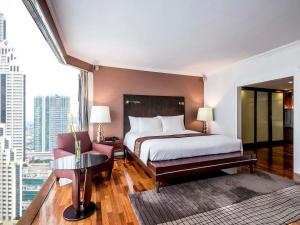 a hotel room with a bed and a large window at Pullman Bangkok Hotel G in Bangkok +138 photos