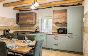 a kitchen with a table and chairs and a kitchen with white cabinets at Stunning Home In Krsan in Kršan