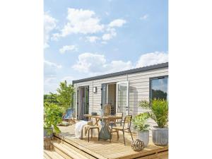 a deck with a table and chairs on a house at Cozy Caravan Escape for 6 in Vierhuizen