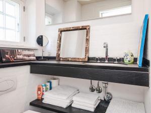 a bathroom with a sink and a mirror and towels at Home with Spa and Fireplace in Fanø +22 photos