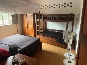 a bedroom with two bunk beds and a fan at Villa Cali SONOMA in Sambava