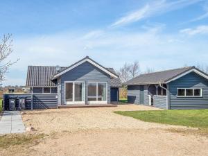 a home with a blue house with a yard at 8 person holiday home in Tarm in Tarm