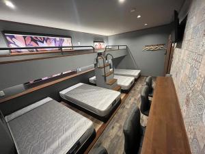 a room with three bunk beds and a table at 安全な個室貸切に広々した共用スペースの喜久屋コテージクレア in Yamanakako