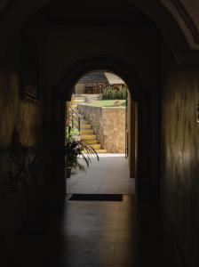 ein dunkler Flur mit einem Torbogen und einer Treppe in einem Gebäude in der Unterkunft Hotel Rinconada del Convento - Izamal in Izamal