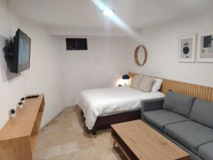 a small room with a bed and a couch at CHOLULA SUITES in Cholula