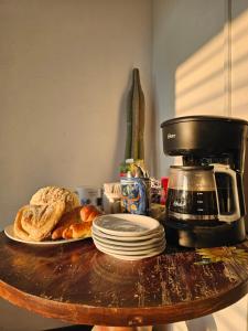 a table with a coffee maker and a plate of bread at CHOLULA SUITES in Cholula