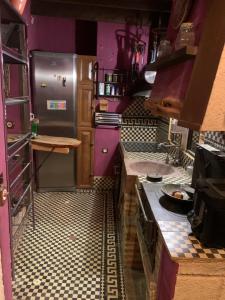 a large kitchen with purple walls and appliances at La Gata Negraa in Bácor