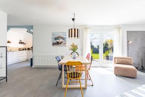 a kitchen and living room with a table and chairs at Cottage am Deich Whg Mareile in Uelvesbüll
