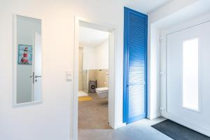 a bathroom with a blue door and a toilet at Cottage am Deich Whg Mareile in Uelvesbüll +33 photos