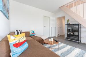 a living room with a couch and a table at Cottage am Deich Whg Marlene in Uelvesbüll