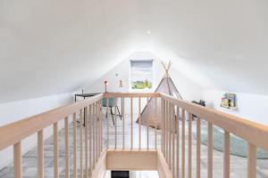 a staircase in a home with white walls and wooden railings at Cottage am Deich Whg Marlene in Uelvesbüll