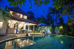 eine Villa mit Swimmingpool bei Nacht in der Unterkunft Villa Alam Biru Gardenia in Seminyak