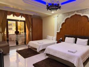 a bedroom with two beds and a chandelier at Hotel Troya in Ibarra +10 photos