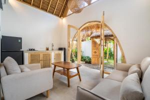 a living room with two couches and a table at Villa Anak Ikan in Gili Islands
