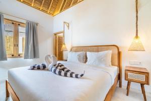 a bedroom with a bed with a stuffed animal on it at Villa Anak Ikan in Gili Islands +20 photos