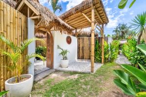 an entrance to a house with a wooden fence and plants at Villa Anak Ikan in Gili Islands