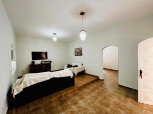 a room with two beds and a table in it at Casa Vitória in Aparecida +18 photos