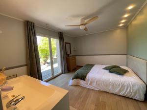 a bedroom with a bed and a bathroom with a sink at 15 min from Lyon Fresh Peaceful Room with Pool and Garden in Dardilly