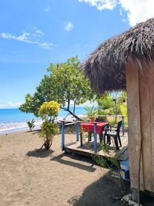 a hut with a table and chairs on the beach at Perla del cabo in Arusí