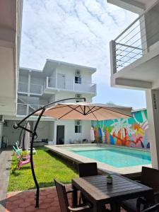 eine Terrasse mit Tisch und Sonnenschirm neben einem Swimmingpool in der Unterkunft Hotel Punta Cometa Tecolutla in Tecolutla
