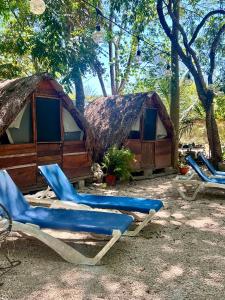 a group of lounge chairs in front of a cabin at Hostalito Lahar in Bacalar