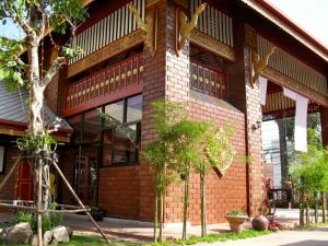 a brick building with trees in front of it at Irawadee Resort in Mae Sot