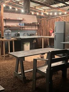 a wooden picnic table in a kitchen with a refrigerator at Hostalito Lahar in Bacalar +20 photos