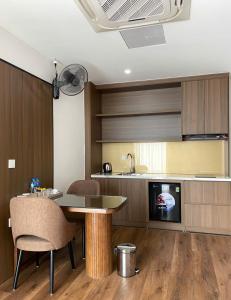 a kitchen with a table and chairs and a tv at ASEAN MINH NGUYỆT Hotel in Nhân Mỹ