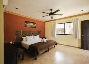 ein Schlafzimmer mit Bett und Deckenventilator in der Unterkunft Hotel Rinconada del Convento - Izamal in Izamal
