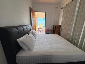 a bedroom with a large bed with white pillows at Queen house in Waikabubak +9 photos