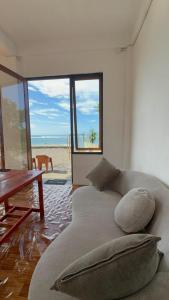 a couch in a room with a view of the beach at Queen house in Waikabubak