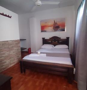 a bedroom with a bed with a painting on the wall at Casa hotel salcon la floresta in Barrancabermeja