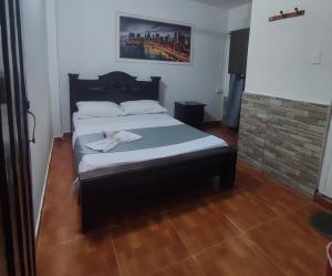 a bedroom with a bed and a brick fireplace at Casa hotel salcon la floresta in Barrancabermeja +2 photos