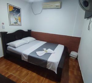a bedroom with a bed with a towel on it at Casa hotel salcon la floresta in Barrancabermeja