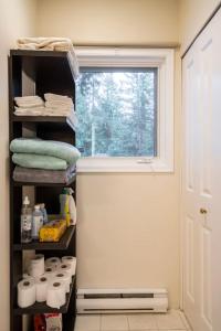 a bathroom with a window and a shelf with towels at Bright and Spacious Upper Level House, Great Area in North Vancouver +42 photos
