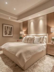 a bedroom with a large white bed with a wall at Oscar Apartments in Cairo
