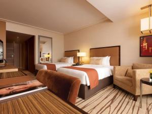 a hotel room with two beds and a couch at Oscar Apartments in Cairo